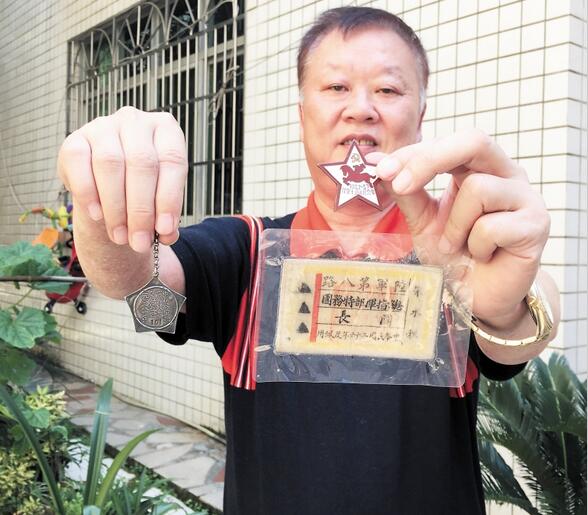 　　朱桂俭展示父亲曾佩戴过的布胸标、红星奖章和纪念章。　　长沙晚报记者 颜开云 摄