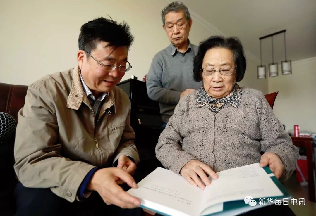 屠呦呦（右）向本报记者介绍青蒿素相关文献